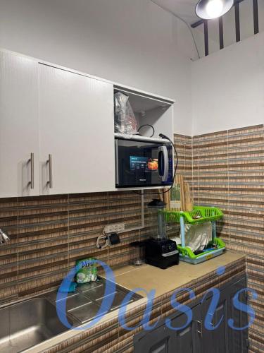 una cucina con lavello e microonde di Oasis a Cotonou