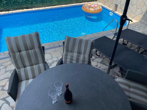 a table with wine glasses on it next to a swimming pool at APP Rebecca - private pool in Brtonigla
