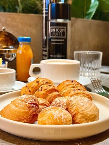 a white plate of pastries on a table at Unicum Suite Grande Archivio Napoli Centro Storico in Naples