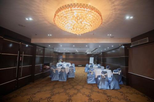 a banquet room with tables and a chandelier at Ethnotel, Kolkata Airport in Kolkata