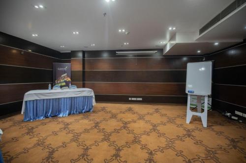 a room with a stage with a table and a podium at Ethnotel, Kolkata Airport in Kolkata