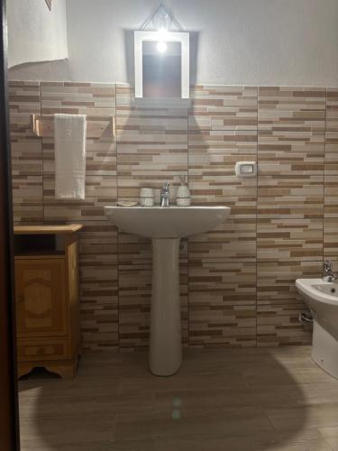 a bathroom with a sink and two toilets at Domo Via Ozieri in Iglesias