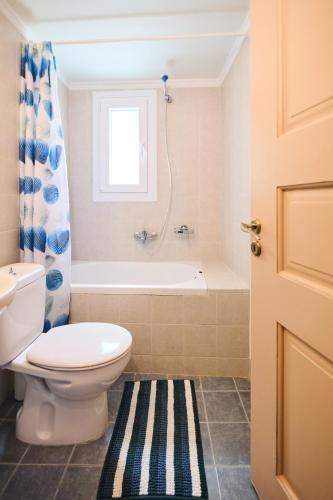 a bathroom with a toilet and a bath tub at D BERNARDAKI Garden House in Mytilene