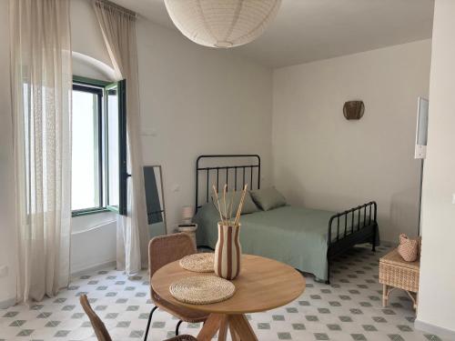 a living room with a table and a bed at B&B Casa Uliva in Castellaneta