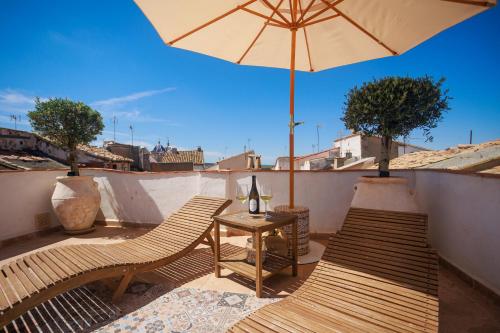 due sedie e un tavolo con ombrellone su un balcone di Villa Valeria, Casa con Cueva privada del 1748 a Requena
