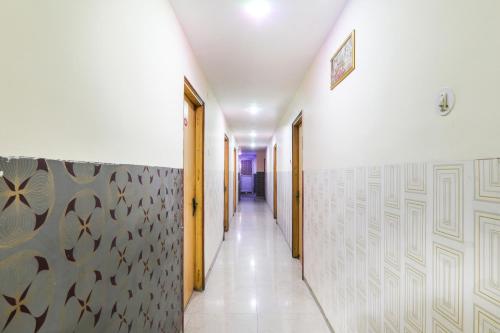 a corridor with white walls and a hallway with yellow doors at Hotel O Priyal in Chās