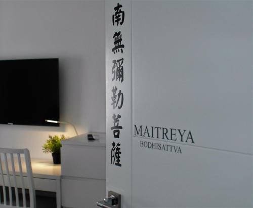 a door in a room with a desk and a television at JINGTU Wellness & Spa B&B in Comares