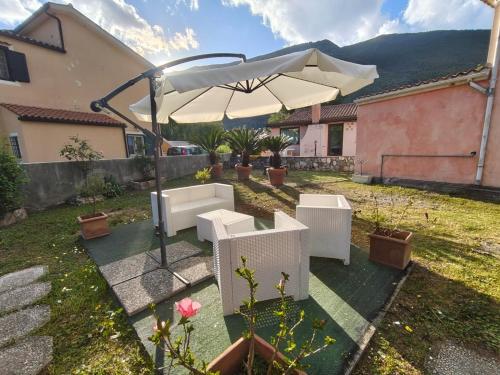 a patio with an umbrella and chairs and a table at Michi's House Casa Vacanze in Maratea