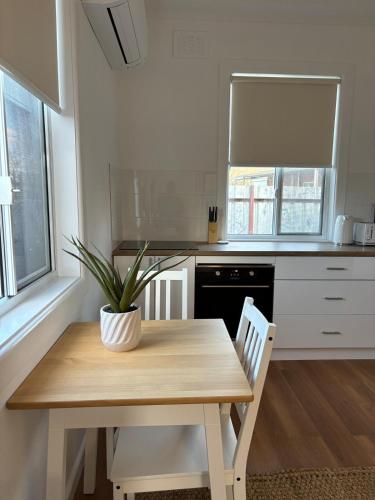 a kitchen with a wooden table with a potted plant on it at Eliza's Place - CWA Coonamble in Coonamble