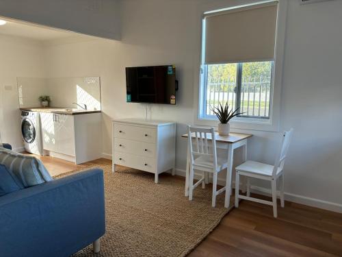 a living room with a table and a dining room at Eliza's Place - CWA Coonamble in Coonamble