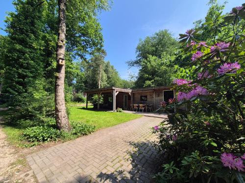 a house with a pavilion in a garden with flowers at Boshuisje in Nutter