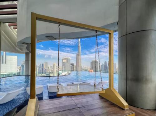 a swing in a room with a view of the city at WonderfulStay at Paramount Residences - Highest Infinity Pool - Burj Khalifa View - Brand New Luxury Apartments in Dubai