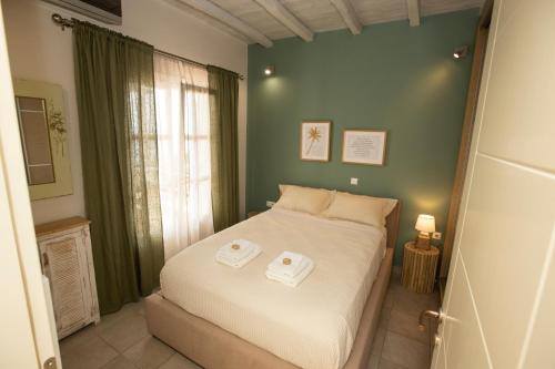 Un dormitorio con una cama con dos toallas encima. en Golden Palm Tree Maisonette, en Víssa