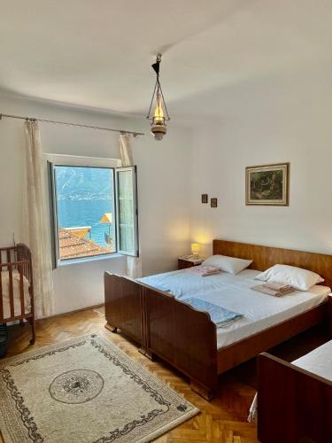 a bedroom with a bed and a large window at Lemon tree villa in Kotor