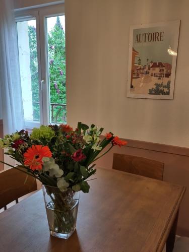 un vase rempli de fleurs posé sur une table dans l'établissement Grand Appartement avec Jardin Bretenoux, à Bretenoux
