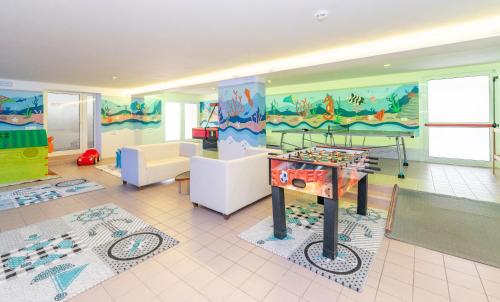a childrens room with a foosball table in the middle at Victoria Frontemare Beach & Spa Hotel Jesolo in Lido di Jesolo