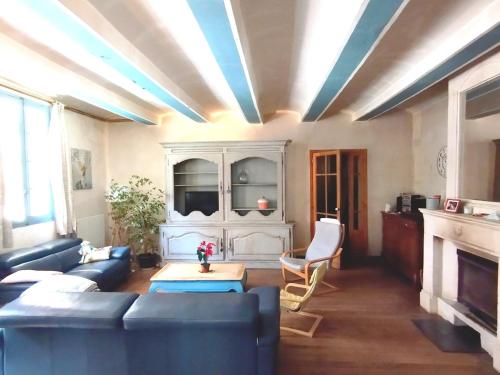 un salon avec un canapé et une table dans l'établissement Delighting young and old alike, à Saint-Quentin-la-Poterie