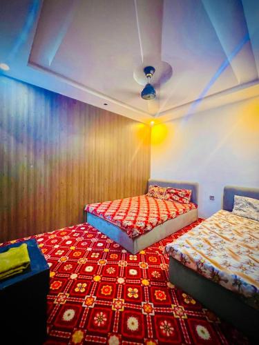 two beds sitting next to each other in a room at AL AQSA SUiTES Guest House Islamabad in Islamabad