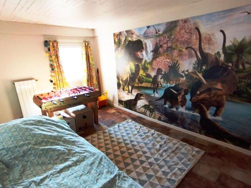 - une chambre avec une fresque murale représentant des dinosaures dans l'établissement Delighting young and old alike, à Saint-Quentin-la-Poterie