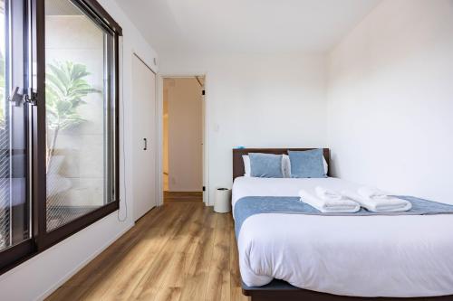 a bedroom with a bed and a large window at First Choice in Tokyo