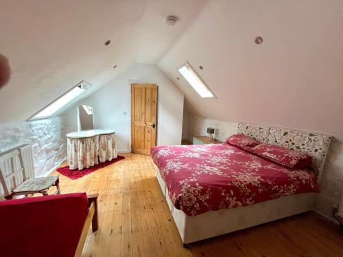 ein Schlafzimmer mit einem Bett und einem Tisch darin in der Unterkunft The Barn @ Mill Haven Place, 3 bedroom cottage in Haverfordwest