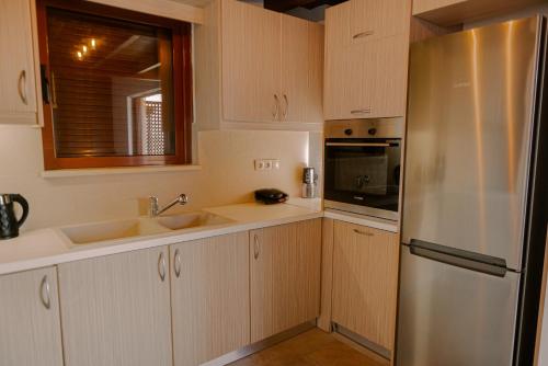 a kitchen with white cabinets and a stainless steel refrigerator at OntasView Rodia in Rodia