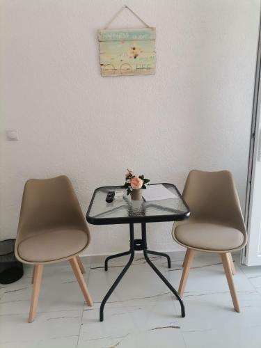 a table with two chairs and a table with flowers on it at Rooms Kirovi - Star Dojran in Star Dojran