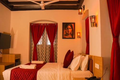 a bedroom with two beds with red curtains and a window at Chithrapuri Heritage Hotels Pvt Ltd in Alattūr