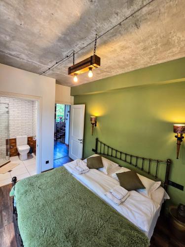 a bedroom with a bed with a green wall at Villa Vejini in Mamkoda