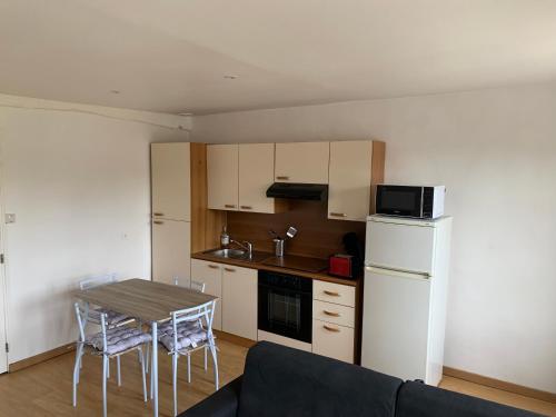une petite cuisine avec une table et un canapé dans l'établissement Charmant T2 meublé, à Saint-Laurent-en-Caux