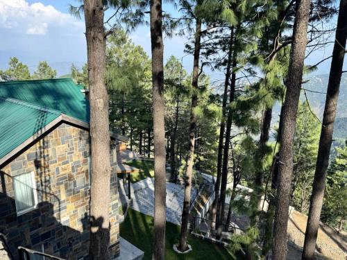 a house with a green roof and some trees at Haven Lodge KhairaGali - Pine Ridge Residences #3 in Khaira Gali