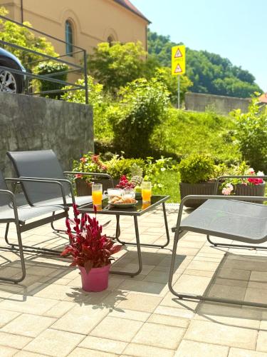 a patio with chairs and a table with a plate of food at Apartman Thermea in Krapinske Toplice