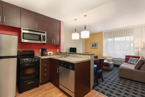 a kitchen with a microwave and a living room at TownePlace Suites by Marriott Harrisburg West/Mechanicsburg in Mechanicsburg