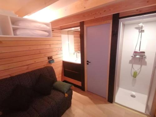 a living room with a couch and a door at Petit cocon centre MONT DORE in Le Mont-Dore