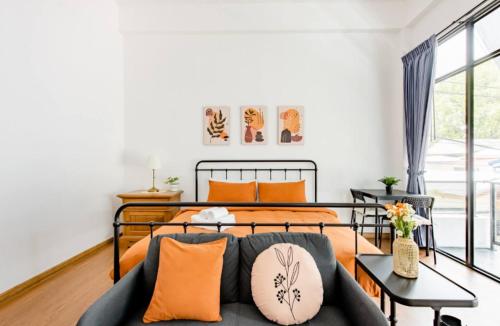 a bedroom with a bed with orange pillows at Homemade Ice cream house in local village in Bangkok