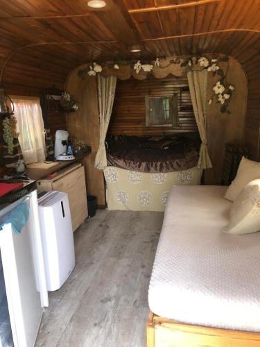 une petite chambre avec un lit et une cuisine dans l'établissement Roulotte au bord du canal du midi argeliers, à Argeliers