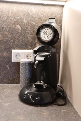 a coffee maker with a clock on top of it at cozy cube 1 Luxury Apartments, nah an der Messe, 30 Minuten zu den Bergen und Seen, 20 Minuten nach München in Glonn