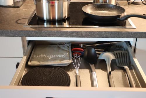 a drawer filled with kitchen utensils in a cabinet at cozy cube 1 Luxury Apartments, nah an der Messe, 30 Minuten zu den Bergen und Seen, 20 Minuten nach München in Glonn