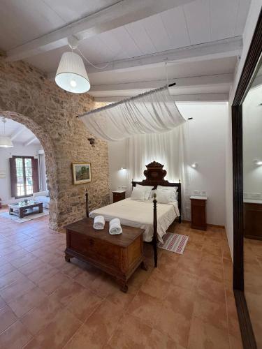 a bedroom with a large bed and a stone wall at Agroturismo Finca Dalt Murada in Binissalem