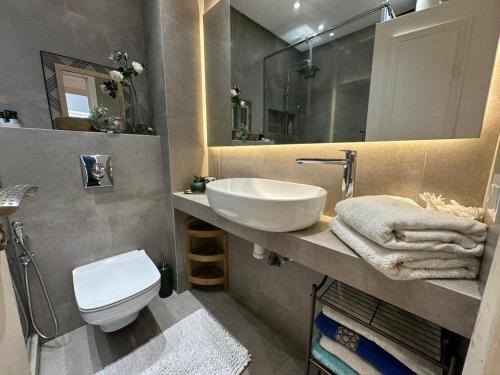 łazienka z umywalką, toaletą i lustrem w obiekcie Appartement moderne à Bourgogne 2 chambre w mieście Casablanca-Port