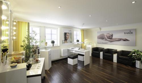 a room with a hair salon with black and white furniture at Hotel Bayerischer Hof in Lindau