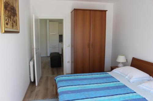 a bedroom with a bed with a blue blanket at Apartment Aleksandar in Mošćenička Draga