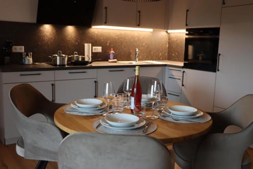 a table with plates and glasses on it in a kitchen at cozy cube 1 Luxury Apartments, nah an der Messe, 30 Minuten zu den Bergen und Seen, 20 Minuten nach München in Glonn