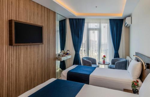 a hotel room with two beds and a television at Airport Waves Hotel in Arnavutköy