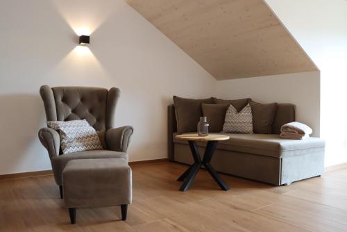 a living room with a couch and a chair and a table at cozy cube 1 Luxury Apartments, nah an der Messe, 30 Minuten zu den Bergen und Seen, 20 Minuten nach München in Glonn