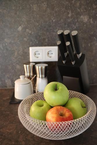 a bowl of apples in a basket on a counter at cozy cube 1 Luxury Apartments, nah an der Messe, 30 Minuten zu den Bergen und Seen, 20 Minuten nach München in Glonn