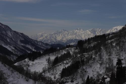 a snow covered mountain range with trees and mountains at UNPLAN Residence suite in Chikuni