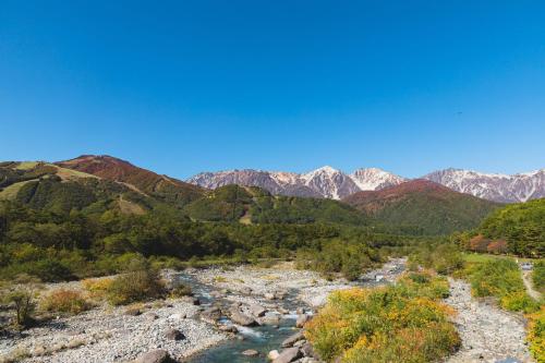 a view of a river with mountains in the background at UNPLAN Residence suite in Chikuni