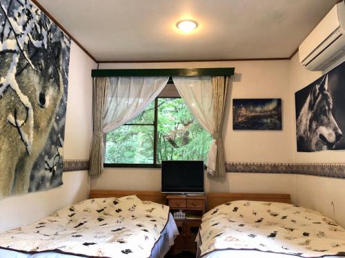 a bedroom with two beds and a window at ドッグランドサムデイ in Minamitsuru