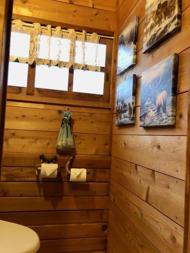 a bathroom with wood paneled walls and a toilet at ドッグランドサムデイ in Minamitsuru
